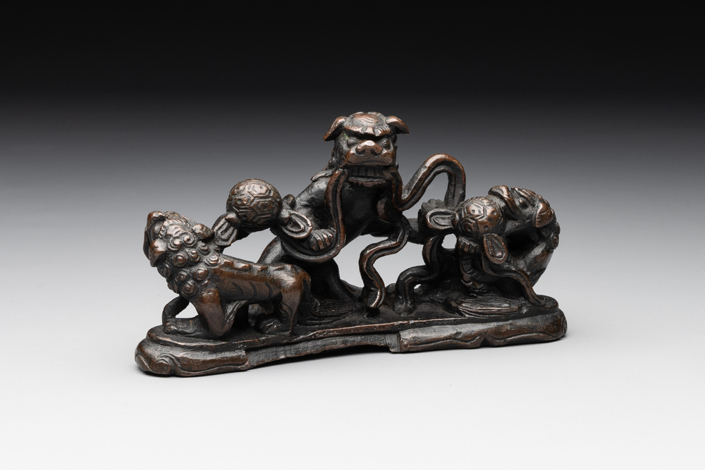 A rare Chinese bronze 'three dancing lions' paperweight or brush rest, Ming