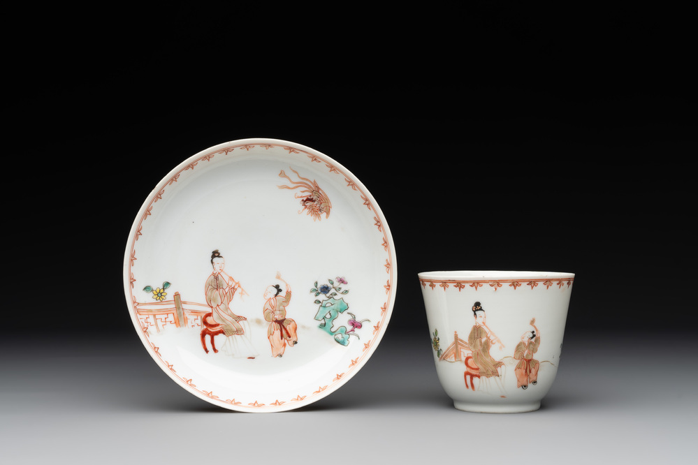 A Chinese famille rose cup and saucer with a lady playing flute, a boy and a phoenix, Qianlong