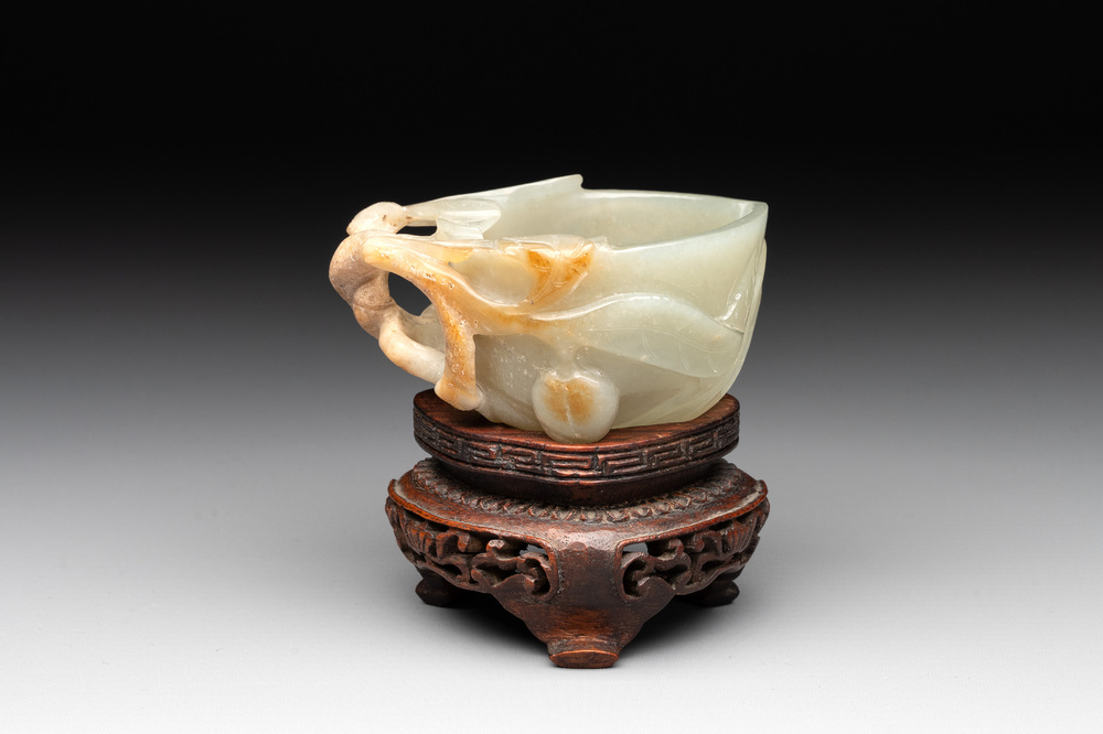 A Chinese jade peach-shaped brush washer on wooden stand, 19th C.