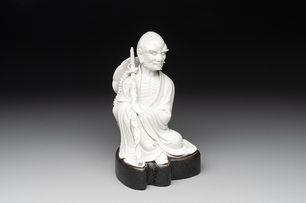 A Chinese Dehua blanc de Chine Luohan on wooden stand, 19/20th C.