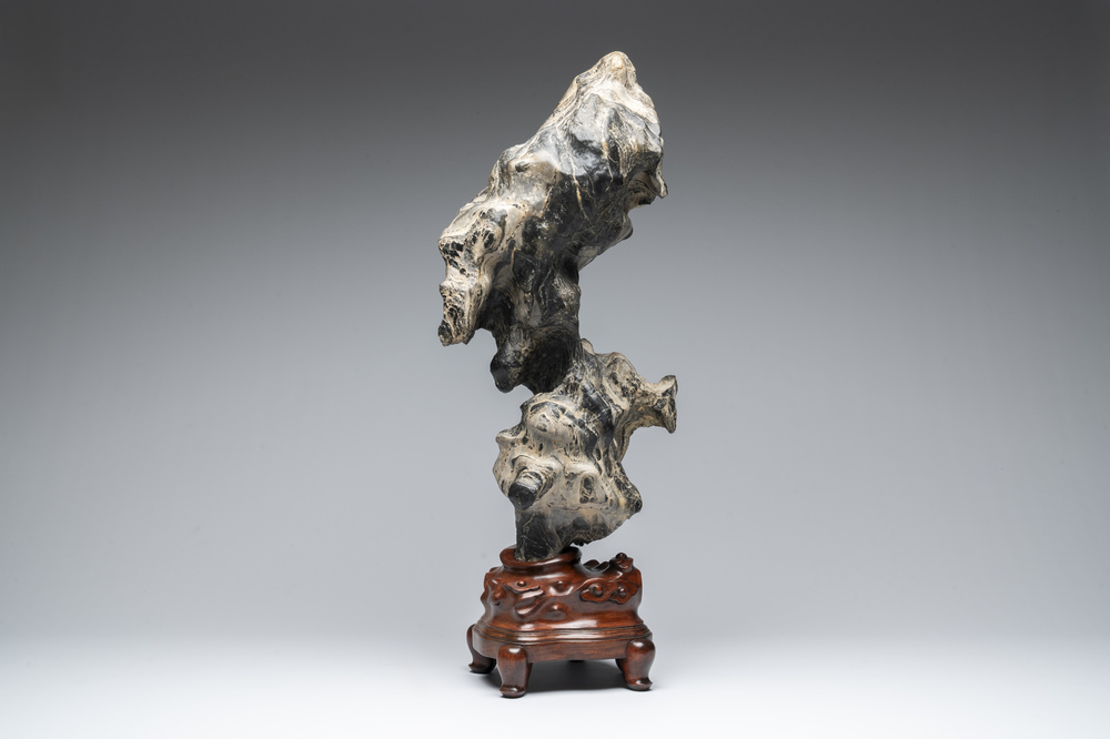 A Chinese green Lingbi stone scholar's rock on wooden stand, 20th C.