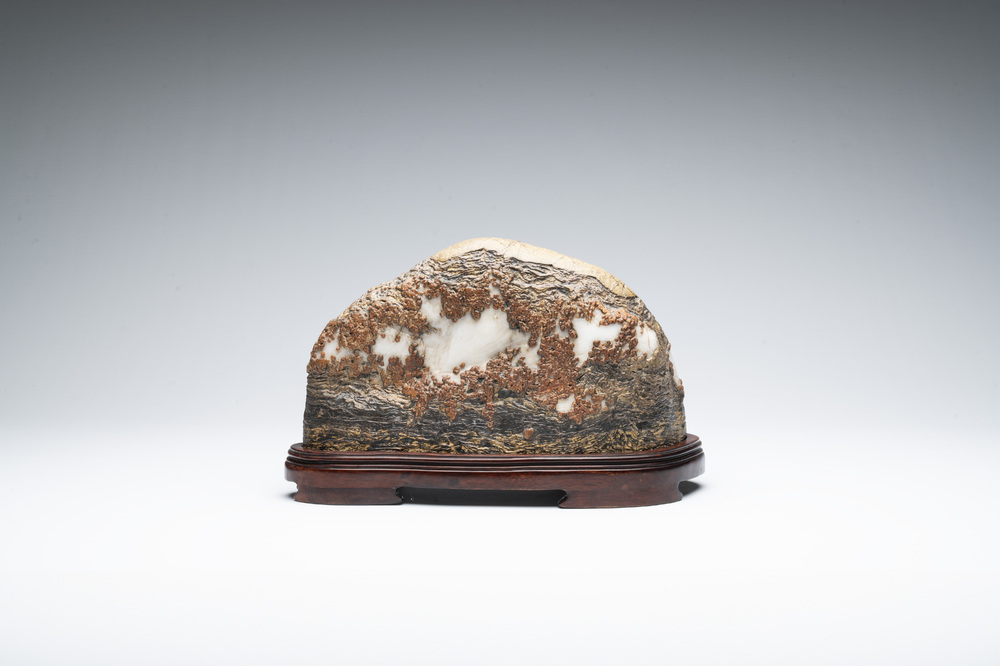 A Chinese wucai Lingbi stone scholar's rock on wooden stand, 20th C.