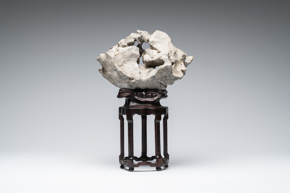 A Chinese Taihu stone scholar's rock on wooden stand, 20th C.