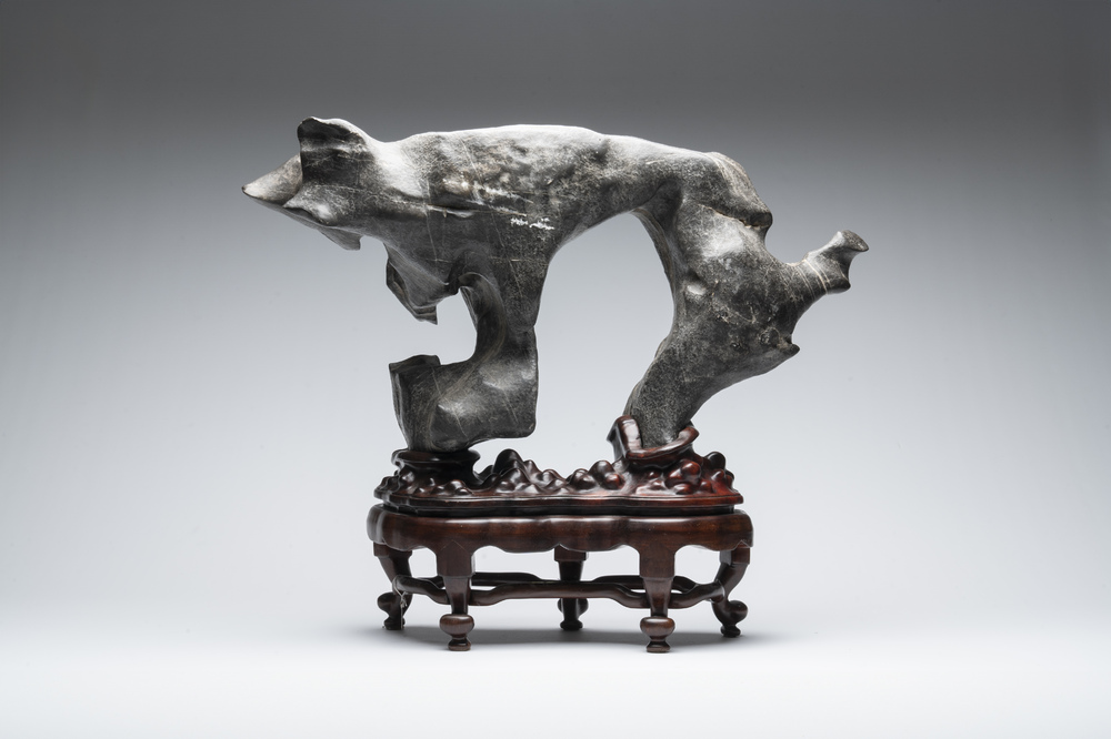 A large Chinese Lingbi stone scholar's rock on wooden stand, 19/20th C.