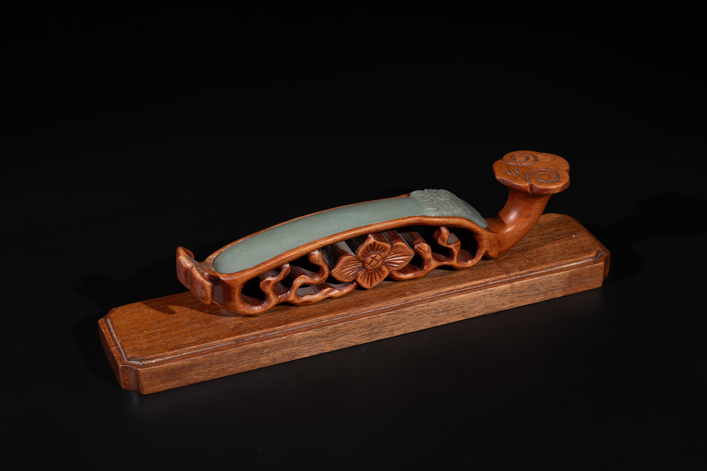 A Chinese pale celadon jade 'double happiness' hairpin on a ruyi-shaped wooden stand, 19th C.