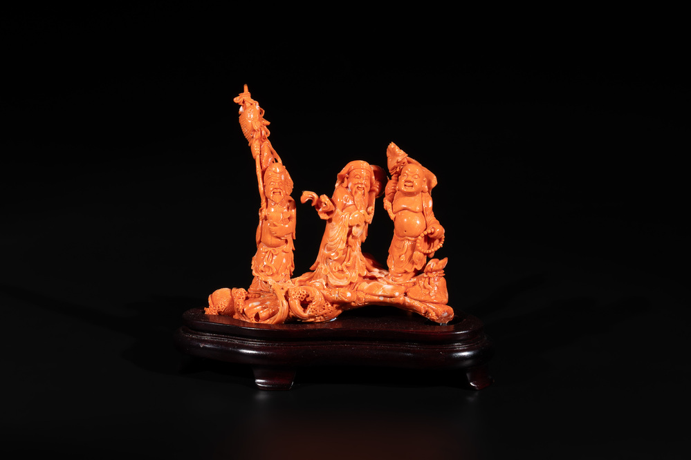 A Chinese red coral 'Sanxing' group on wooden stand, 19/20th C.