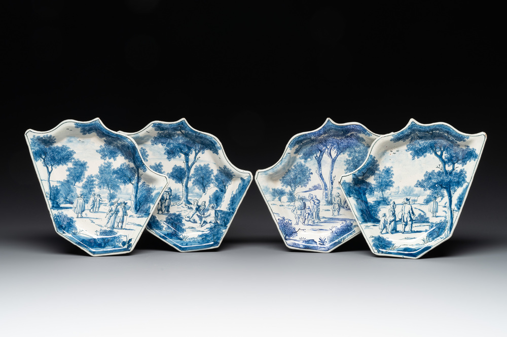 Four fine blue and white Dutch Delft leaf-shaped dishes with travellers in a landscape, early 18th C.