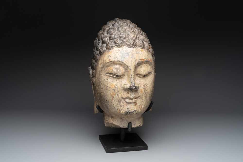 A large Chinese stone head of Buddha with traces of gilding and polychromy, Ming