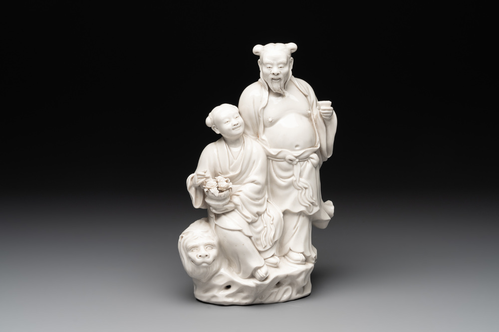 A Chinese Dehua blanc de Chine group of a man and a seated boy on a lion, 20th C.