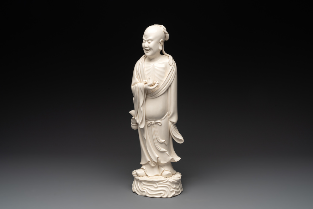A Chinese Dehua blanc de Chine figure of a sage holding a peach, 20th C.