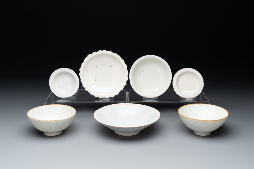 Four Chinese white-glazed saucers and three bowls, Yuan/Ming