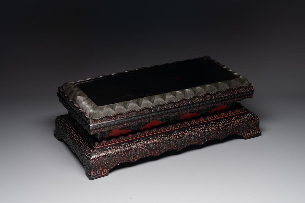 A Chinese rectangular carved red and black lacquer stand, 20th C.