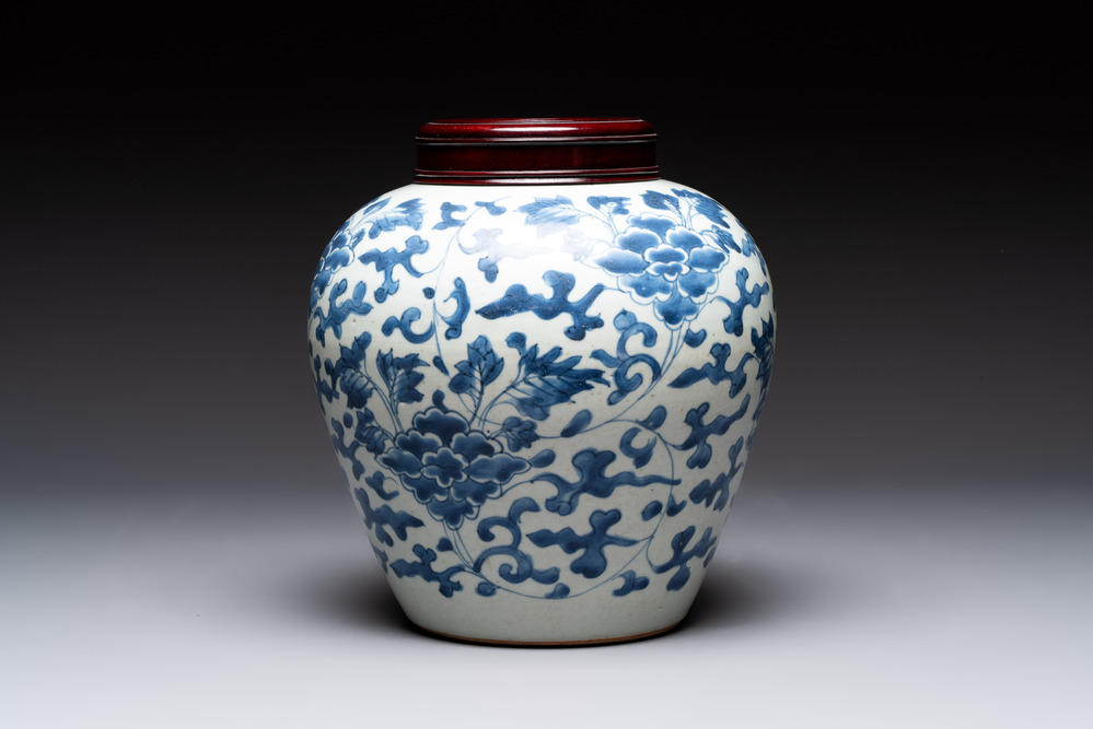 A Chinese blue and white 'peony scrolls' vase and wooden cover, Transitional period