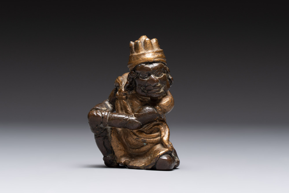 A small Chinese gilt bronze paperweight in the form of a kneeling foreigner, Ming