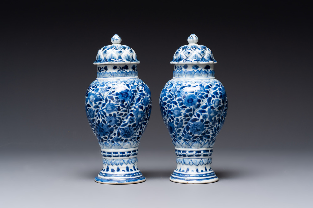 A pair of Chinese blue and white vases and covers with floral design, Kangxi