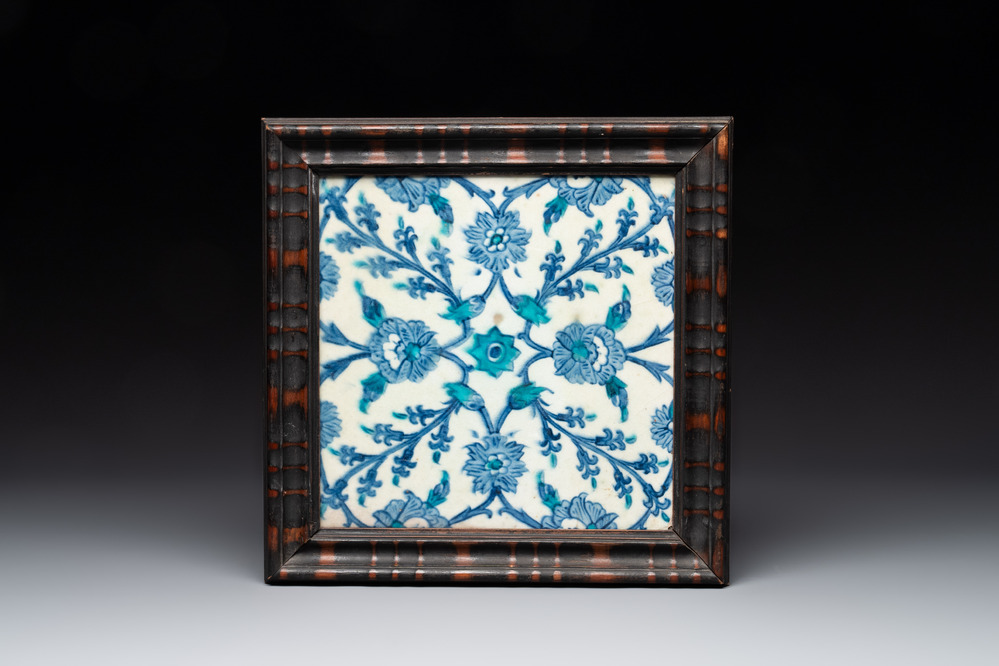 A framed blue, white and turquoise Iznik pottery tile with floral design, Turkey, 17th C.