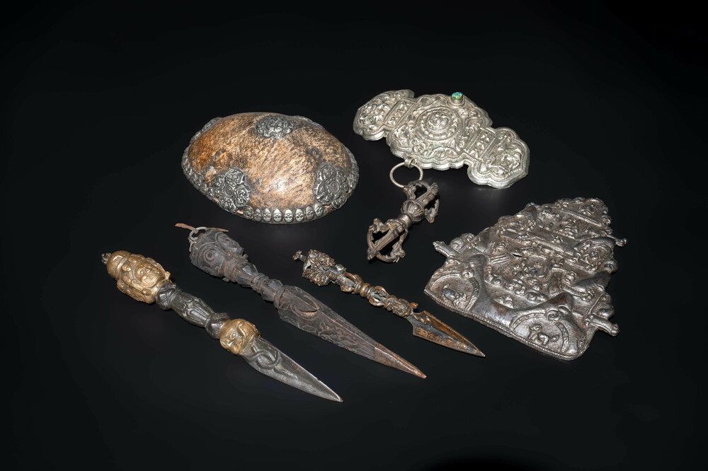 Four Tibetan bronze and wooden phurbas, a 'kapala' or skull-bowl and two silver ornaments, 19th C.