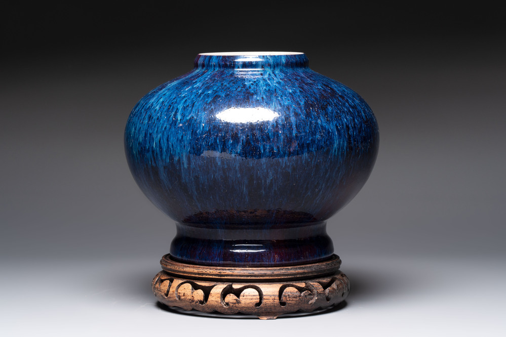 A Chinese flamb&eacute;-glazed vase on wooden stand, 19th C.