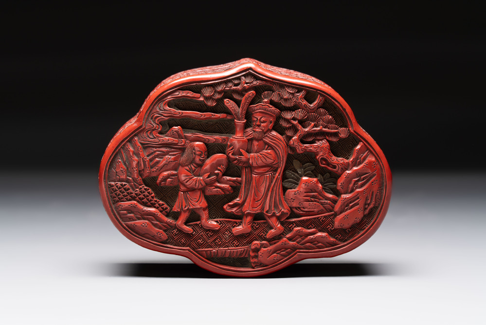 A fine Chinese red cinnabar lacquer ruyi-form 'Ba Man Xian Bao 八蠻獻寶' box and cover, Qianlong