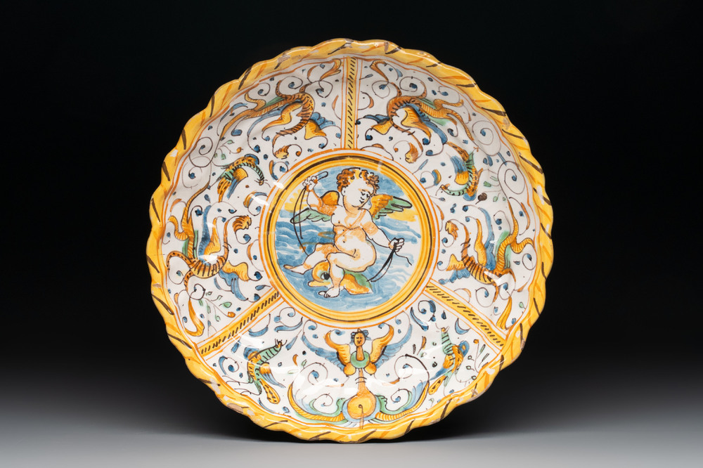 A polychrome Italian maiolica crespina with a putto on a dolphin, Deruta, 17th C.