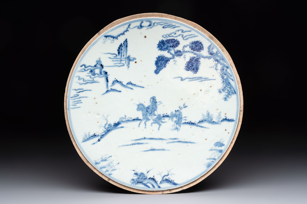A Chinese blue and white circular plaque with two figures in a landscape, 19/20th C.