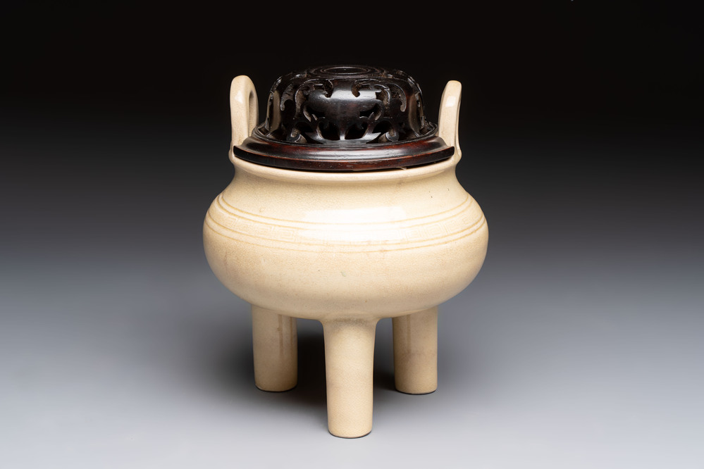 A Chinese Swatow cream-glazed tripod censer with wooden cover, 18/19th C.