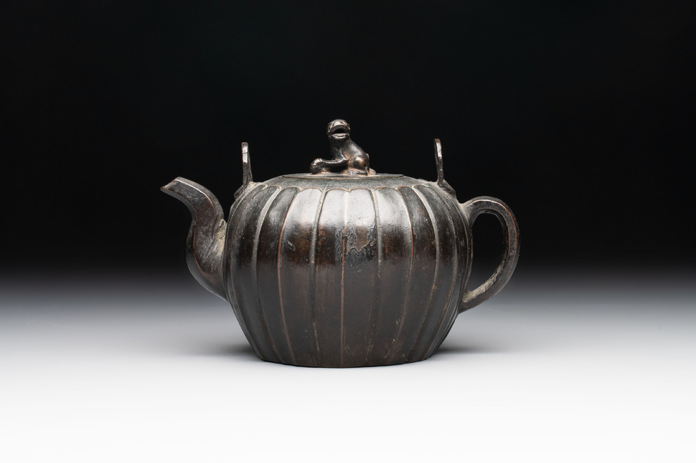 A Chinese bronze teapot and cover with a lion-shaped finial, Yuan