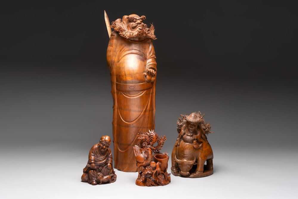 Three Chinese carved bamboo figures and a boxwood carving of a phoenix, 20th C.