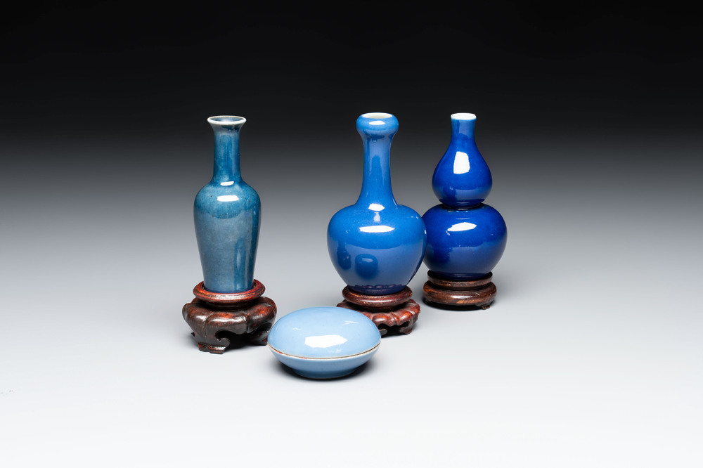Three Chinese blue-glazed miniature vases on wooden stands and a claire-de-lune seal paste box and cover, 19th C.