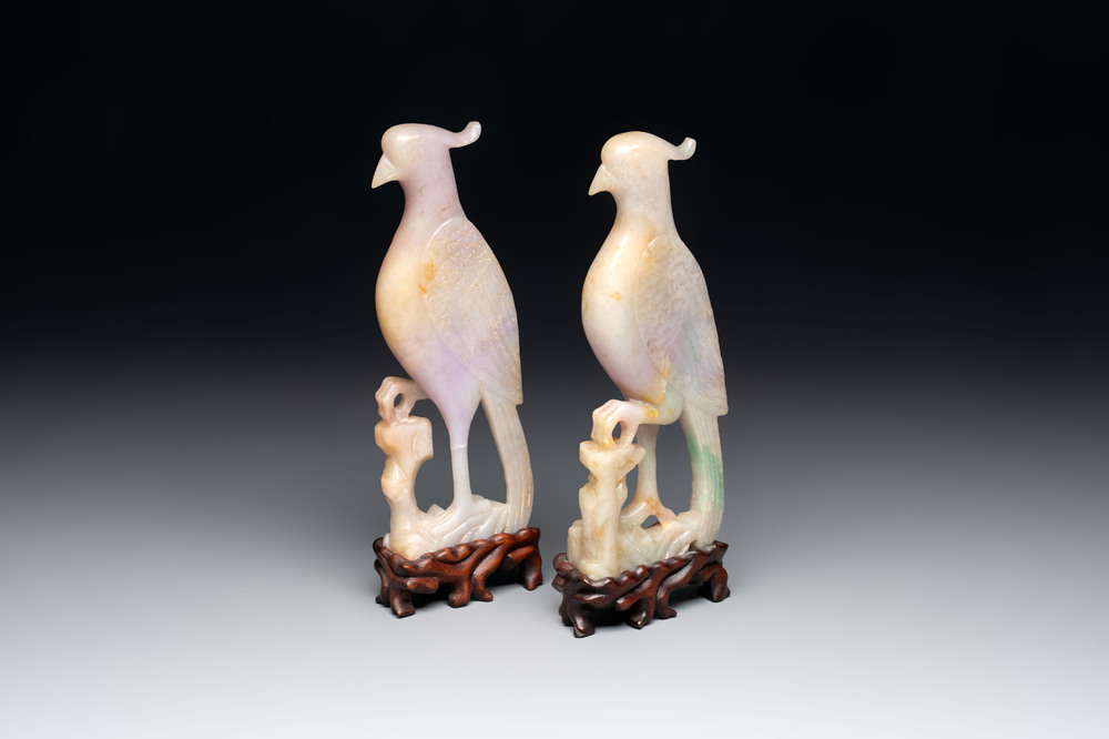 A pair of Chinese lavender and emerald-green jadeite parrots on wooden stands, 19th C.