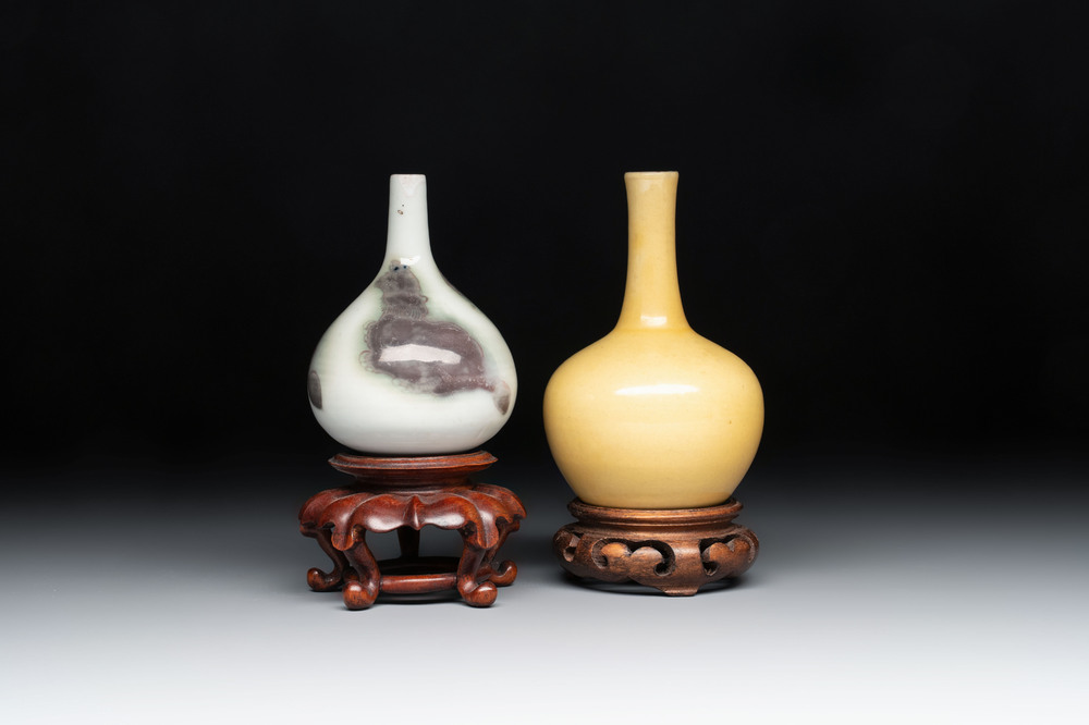 A Chinese copper-red 'mythical beasts' vase and a yellow-glazed bottle vase, with two wooden stands, Kangxi and later