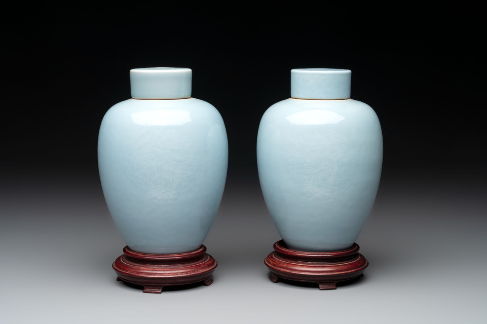 A pair of Chinese claire-de-lune jars and covers on wooden stands, Kangxi mark, 19th C.