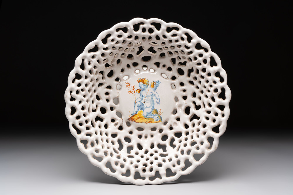 A reticulated Italian blue, white and yellow 'putto' tazza, Faenza, 17th C.