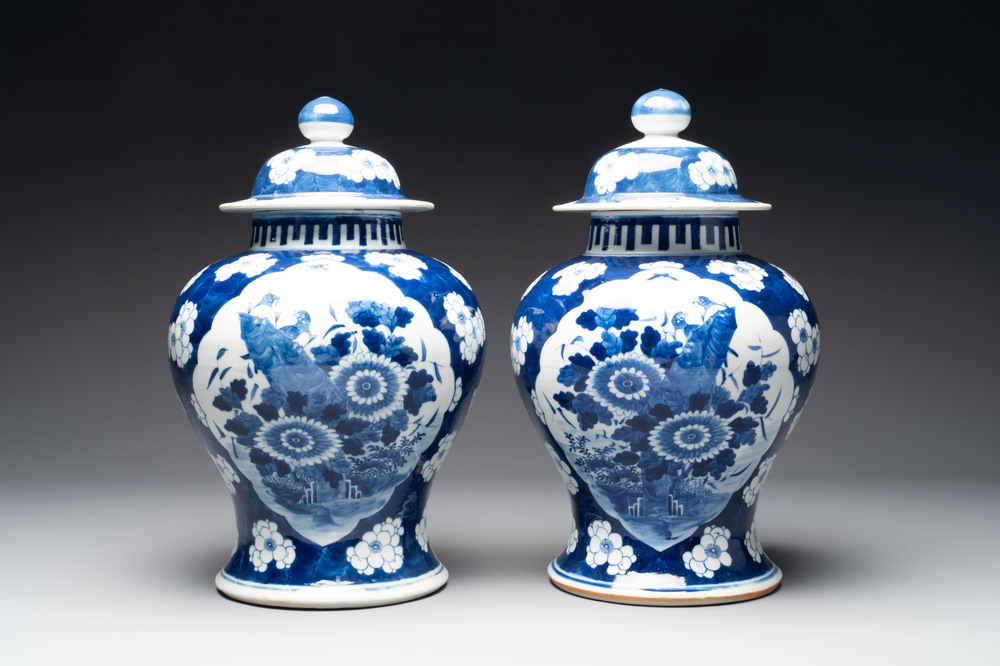 A pair of Chinese blue and white covered vases with floral design, 19th C.