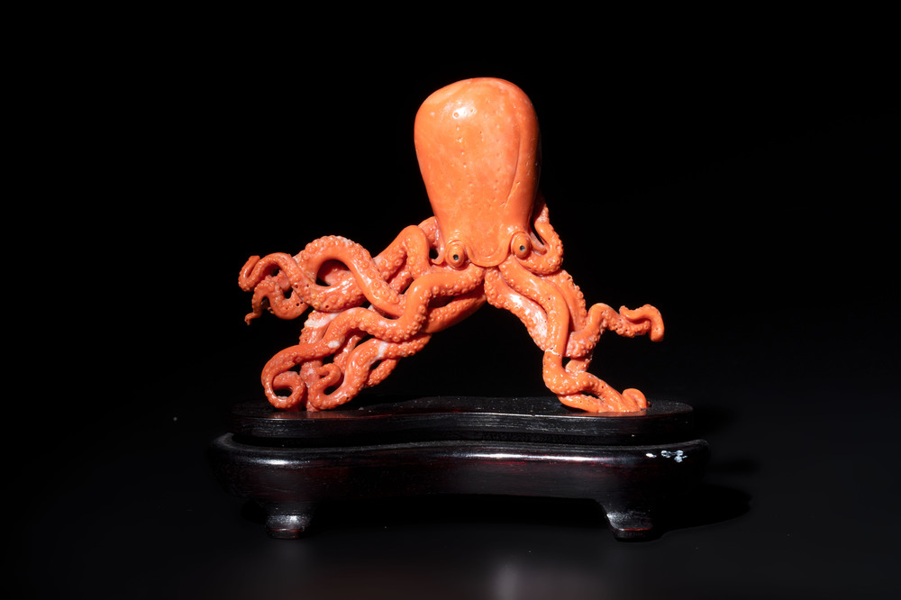 A Japanese red coral sculpture of an octopus on wooden stand, 19/20th C.