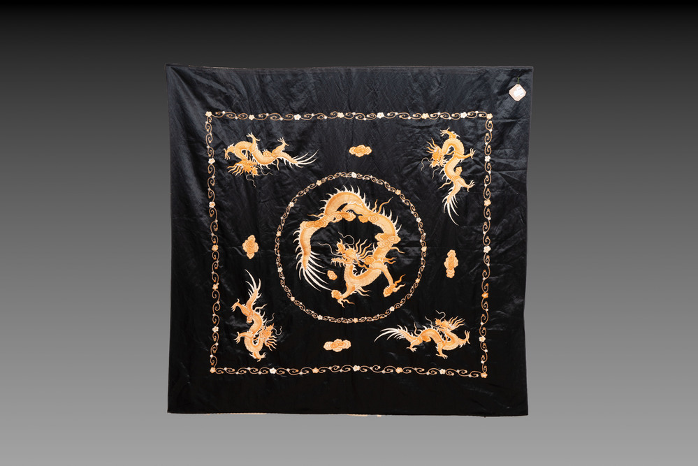A Chinese black-ground embroidered silk panel with a four-clawed dragon, 19th C.