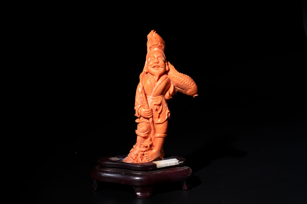 A Japanese red coral sculpture of a fisherman on wooden stand, 19/20th C.