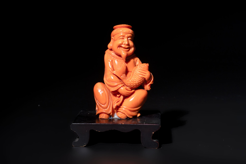 A Japanese red coral sculpture of a fisherman on wooden stand, 19/20th C.