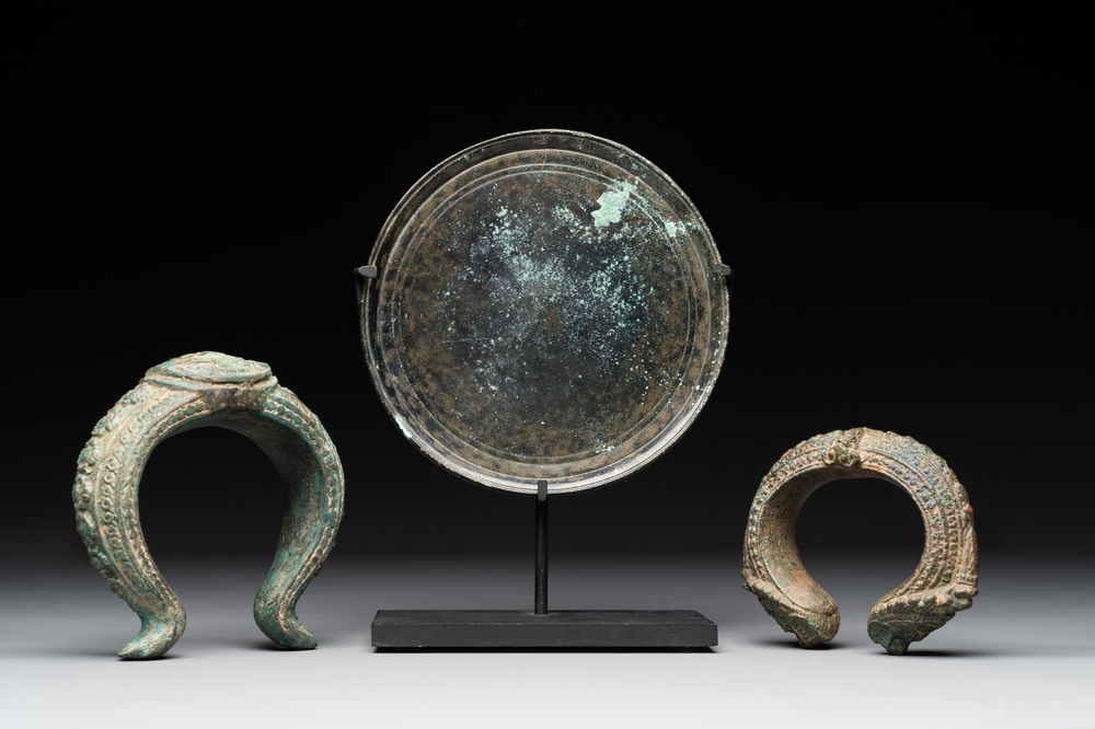 A bronze mirror, a bracelet with a royal or noble emblem and a bronze bracelet with two tiger heads, Cambodia, 12th C.