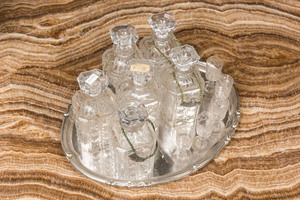 Six faceted glass liquor bottles and five engraved glasses on a silvered tray, 20th C.
