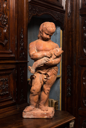 A terracotta figure of a boy holding a fish, 19th C.