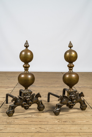 A pair of bronze andirons with lion heads and winged horses, 19/20th C.