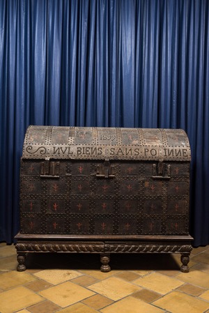 A large French wooden 'bahut' trunk with leather upholstery and wrought iron fittings on a wooden base, dated 1599 but possibly later