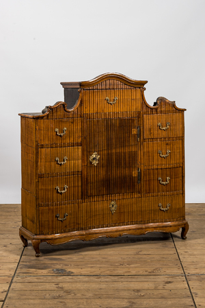 A German low ribbed wooden cabinet of drawers with a central door, 19th C.