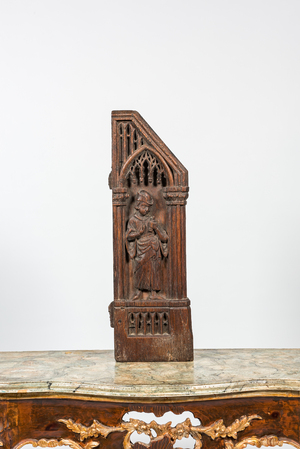 A Flemish carved oak retable fragment depicting a sculptor, 16th C.