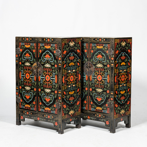 A pair of Chinese black lacquered wooden two-door cabinets with floral design, 20th C.