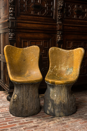 A pair of English naturalistically painted composite stone tree trunk chairs, mid 20th C.