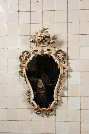 A carved polychrome wooden mirror with floral design, 19th C.