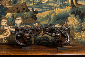 A pair of carved oak reliefs with devils' heads, 17th C.