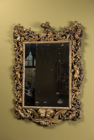 A finely carved polychromed wooden mirror with putti, Italy, 17th C.